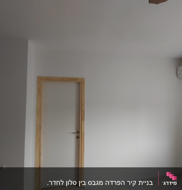 קיר גבס לבן עם דלת עץ ומשקוף